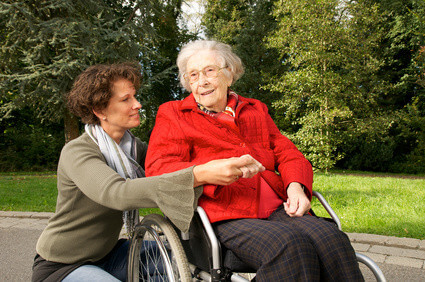 Seniorin im Rollstuhl mit Betreuerin